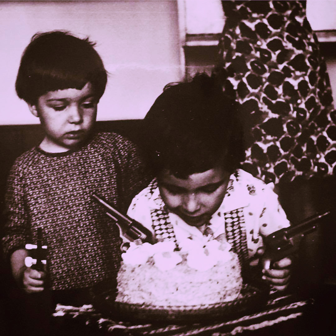 Kids. Zuzana's older brother, armed with toy pistols is protecting a cake, while their their mom fetches something from cupboards